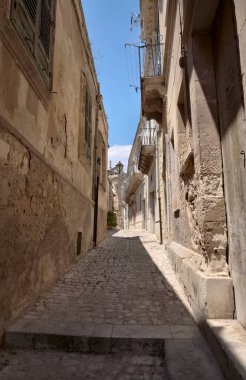 Arka planda İtalya, Sicilya, Scicli (Ragusa ili), eski barok binalar ve Barok Beneventano Sarayı cephesi yer almaktadır.