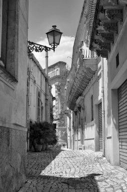 Arka planda İtalya, Sicilya, Scicli (Ragusa ili), eski barok binalar ve Barok Beneventano Sarayı cephesi yer almaktadır. 