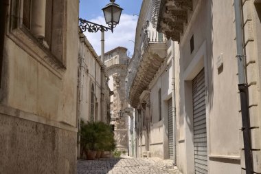 Arka planda İtalya, Sicilya, Scicli (Ragusa ili), eski barok binalar ve Barok Beneventano Sarayı cephesi yer almaktadır. 