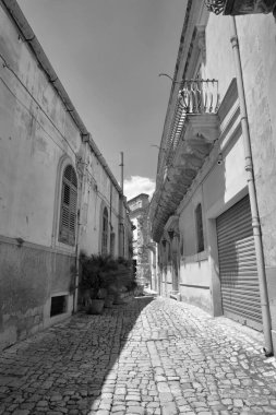 Arka planda İtalya, Sicilya, Scicli (Ragusa ili), eski barok binalar ve Barok Beneventano Sarayı cephesi yer almaktadır. 