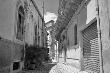 Arka planda İtalya, Sicilya, Scicli (Ragusa ili), eski barok binalar ve Barok Beneventano Sarayı cephesi yer almaktadır. 