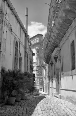 Arka planda İtalya, Sicilya, Scicli (Ragusa ili), eski barok binalar ve Barok Beneventano Sarayı cephesi yer almaktadır. 