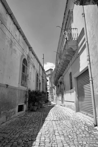 Arka planda İtalya, Sicilya, Scicli (Ragusa ili), eski barok binalar ve Barok Beneventano Sarayı cephesi yer almaktadır. 