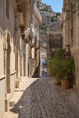 İtalya, Sicilya, Scicli (Ragusa eyaleti), merkezi taşla döşenmiş bir caddedeki barok binaların cepheleri.