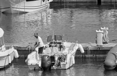 İtalya, Sicilya, Akdeniz, Marina di Ragusa (Ragusa ili); 17 Haziran 2021, limandaki bir motorlu teknede adam - EDITORIAL