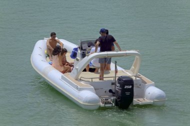 İtalya, Sicilya, Akdeniz, Marina di Ragusa (Ragusa ili); 19 Haziran 2021, limandaki kauçuk bir teknede insanlar - EDITORIAL