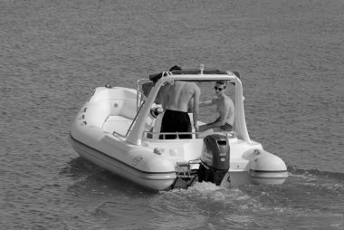 İtalya, Sicilya, Akdeniz, Marina di Ragusa (Ragusa ili); 19 Haziran 2021, limandaki kauçuk bir teknede adamlar - EDITORIAL