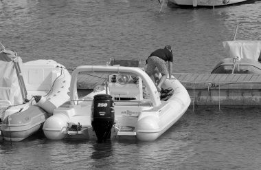 İtalya, Sicilya, Akdeniz, Marina di Ragusa (Ragusa ili); 19 Haziran 2021, limandaki kauçuk bir teknede adamlar - EDITORIAL