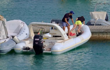 İtalya, Sicilya, Akdeniz, Marina di Ragusa (Ragusa ili); 19 Haziran 2021, limandaki kauçuk bir teknede adamlar - EDITORIAL