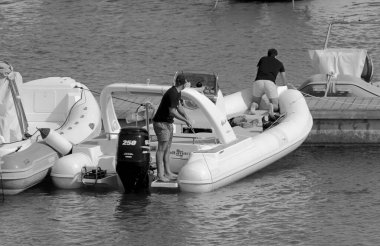 İtalya, Sicilya, Akdeniz, Marina di Ragusa (Ragusa ili); 19 Haziran 2021, limandaki kauçuk bir teknede adamlar - EDITORIAL