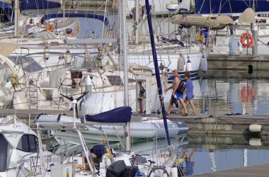 İtalya, Sicilya, Akdeniz, Marina di Ragusa (Ragusa ili); 22 Haziran 2021, limandaki insanlar ve lüks yatlar - EDITORIAL