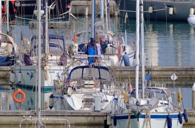 İtalya, Sicilya, Akdeniz, Marina di Ragusa (Ragusa ili); 23 Haziran 2021, limanda insanlar ve yelkenliler - EDITORIAL