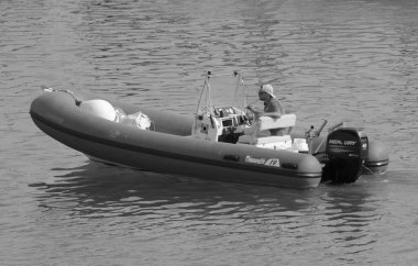 İtalya, Sicilya, Akdeniz, Marina di Ragusa (Ragusa Eyaleti); 24 Haziran 2021, limandaki bir kauçuk teknede adam - EDITORIAL