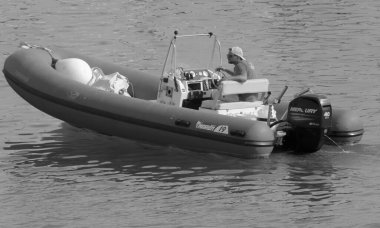 İtalya, Sicilya, Akdeniz, Marina di Ragusa (Ragusa Eyaleti); 24 Haziran 2021, limandaki bir kauçuk teknede adam - EDITORIAL