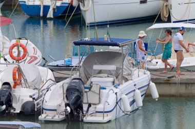 İtalya, Sicilya, Akdeniz, Marina di Ragusa (Ragusa ili); 25 Haziran 2021, limandaki insanlar ve lüks yatlar - EDITORIAL