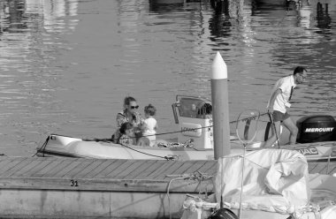 İtalya, Sicilya, Akdeniz, Marina di Ragusa (Ragusa ili); 25 Haziran 2021, limandaki kauçuk bir teknede insanlar - EDITORIAL