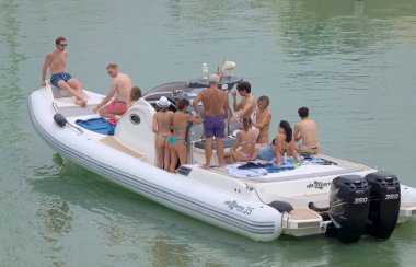 İtalya, Sicilya, Akdeniz, Marina di Ragusa (Ragusa ili); 26 Haziran 2021, limandaki büyük bir kauçuk teknede insanlar - EDITORIAL