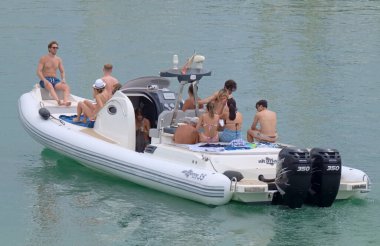 İtalya, Sicilya, Akdeniz, Marina di Ragusa (Ragusa ili); 26 Haziran 2021, limandaki büyük bir kauçuk teknede insanlar - EDITORIAL