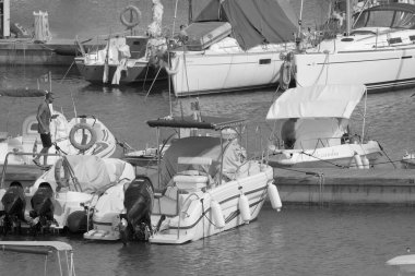 İtalya, Sicilya, Akdeniz, Marina di Ragusa (Ragusa ili); 26 Haziran 2021, limandaki insanlar, motorlu tekneler ve lüks yatlar - EDITORIAL