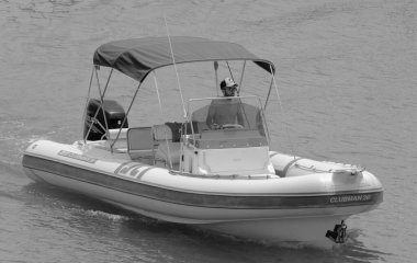 İtalya, Sicilya, Akdeniz, Marina di Ragusa (Ragusa ili); 27 Haziran 2021, limandaki kauçuk bir teknede adam - EDITORIAL