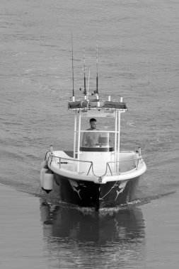 İtalya, Sicilya, Akdeniz, Marina di Ragusa (Ragusa Eyaleti); 29 Haziran 2021, limandaki bir motorlu teknede balıkçı - EDITORIAL