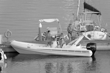 İtalya, Sicilya, Akdeniz, Marina di Ragusa (Ragusa ili); 29 Haziran 2021, limandaki kauçuk bir teknede insanlar - EDITORIAL