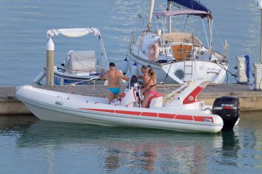 İtalya, Sicilya, Akdeniz, Marina di Ragusa (Ragusa ili); 29 Haziran 2021, limandaki kauçuk bir teknede insanlar - EDITORIAL