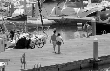 İtalya, Sicilya, Akdeniz, Marina di Ragusa (Ragusa Eyaleti); 2 Temmuz 2021, limandaki insanlar ve lüks yatlar - EDITORIAL