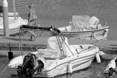 İtalya, Sicilya, Akdeniz, Marina di Ragusa (Ragusa ili); 2 Temmuz 2021, limanda insanlar ve motorlu tekneler - EDITORIAL