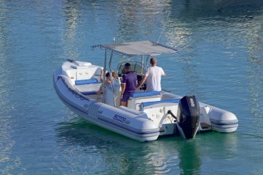 İtalya, Sicilya, Akdeniz, Marina di Ragusa (Ragusa Eyaleti); 3 Temmuz 2021, limandaki kauçuk bir teknede insanlar - EDITORIAL