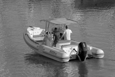 İtalya, Sicilya, Akdeniz, Marina di Ragusa (Ragusa Eyaleti); 3 Temmuz 2021, limandaki kauçuk bir teknede insanlar - EDITORIAL