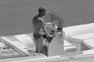 İtalya, Sicilya, Akdeniz, Marina di Ragusa (Ragusa Eyaleti); 10 Temmuz 2021, limandaki kauçuk bir teknede adam - EDITORIAL