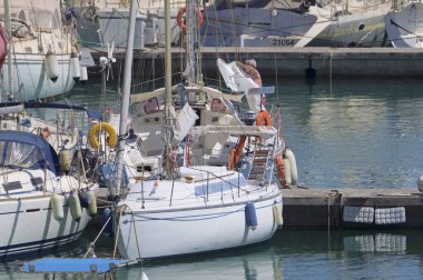 İtalya, Sicilya, Akdeniz, Marina di Ragusa (Ragusa Eyaleti); 10 Temmuz 2021, limandaki bir yelkenli teknesinde adam - EDITORIAL