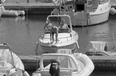 İtalya, Sicilya, Akdeniz, Marina di Ragusa (Ragusa ili); 11 Temmuz 2021, limandaki bir motorlu tekne ve lüks yatlarda yaşayan insanlar - EDITORIAL