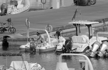 Italy, Sicily, Mediterranean Sea, Marina di Ragusa (Ragusa Province); 13 July 2021, people on a rubber boat and luxury yachts in the port - EDITORIAL