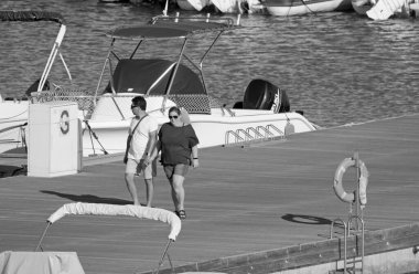 İtalya, Sicilya, Akdeniz, Marina di Ragusa (Ragusa ili); 18 Temmuz 2021, limandaki insanlar, motorlu tekneler ve lüks yatlar - EDITORIAL