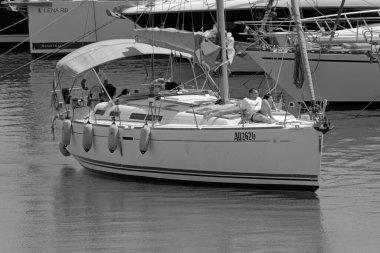 İtalya, Sicilya, Akdeniz, Marina di Ragusa (Ragusa Eyaleti); 20 Temmuz 2021, limandaki bir yelkenli ve lüks yatlarda yaşayan insanlar - EDITORIAL