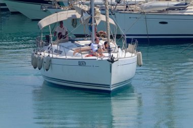 İtalya, Sicilya, Akdeniz, Marina di Ragusa (Ragusa Eyaleti); 20 Temmuz 2021, limandaki bir yelkenli ve lüks yatlarda yaşayan insanlar - EDITORIAL