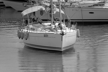 İtalya, Sicilya, Akdeniz, Marina di Ragusa (Ragusa Eyaleti); 20 Temmuz 2021, limandaki bir yelkenli ve lüks yatlarda yaşayan insanlar - EDITORIAL