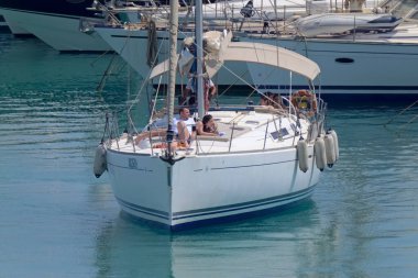 İtalya, Sicilya, Akdeniz, Marina di Ragusa (Ragusa Eyaleti); 20 Temmuz 2021, limandaki bir yelkenli ve lüks yatlarda yaşayan insanlar - EDITORIAL