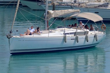 İtalya, Sicilya, Akdeniz, Marina di Ragusa (Ragusa Eyaleti); 20 Temmuz 2021, limandaki bir yelkenli ve lüks yatlarda yaşayan insanlar - EDITORIAL