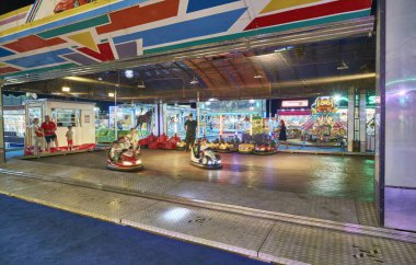 İtalya, Sicilya, Marina di Ragusa (Ragusa Eyaleti), çocuklar gece bir lunaparkta elektrikli araba sürüyorlar.