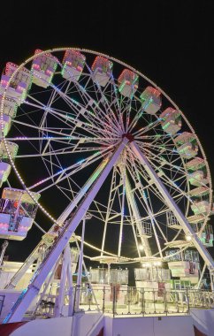 İtalya, Sicilya, Marina di Ragusa (Ragusa Eyaleti), 20 Temmuz 2021, bir lunaparkta geceleyin atlıkarıncalı insanlar