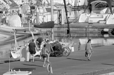 İtalya, Sicilya, Akdeniz, Marina di Ragusa (Ragusa ili); 23 Temmuz 2021, limandaki insanlar ve lüks yatlar - EDITORIAL