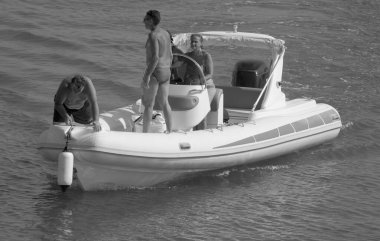 İtalya, Sicilya, Akdeniz, Marina di Ragusa (Ragusa Eyaleti); 25 Temmuz 2021, limandaki kauçuk bir teknede insanlar - EDITORIAL