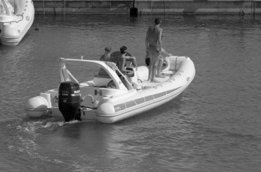 İtalya, Sicilya, Akdeniz, Marina di Ragusa (Ragusa Eyaleti); 25 Temmuz 2021, limandaki kauçuk bir teknede insanlar - EDITORIAL