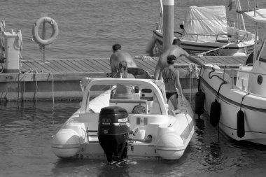 İtalya, Sicilya, Akdeniz, Marina di Ragusa (Ragusa Eyaleti); 25 Temmuz 2021, limandaki kauçuk bir teknede insanlar - EDITORIAL