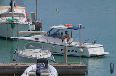 İtalya, Sicilya, Akdeniz, Marina di Ragusa (Ragusa ili); 26 Temmuz 2021, limanda lüks bir yatta çift - EDITORIAL