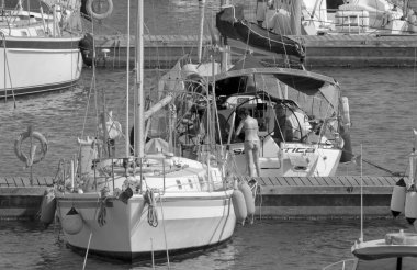 İtalya, Sicilya, Akdeniz, Marina di Ragusa (Ragusa Eyaleti); 29 Temmuz 2021, limandaki bir yelkenli ve lüks yatlarda yaşayan insanlar - EDITORIAL