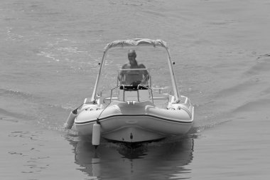 İtalya, Sicilya, Akdeniz, Marina di Ragusa (Ragusa Eyaleti); 1 Ağustos 2021, limandaki kauçuk bir teknede adam - EDITORIAL